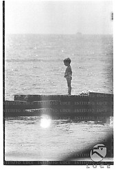 Un bambino in costume ripreso in piedi sul molo di Santa Marinella - campo medio