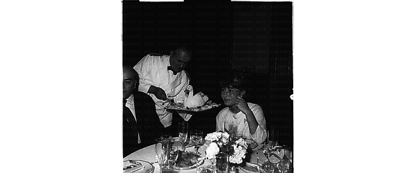 In occasione della comunione ripresi Franca Bettoja ed un uomo seduti al tavolo - piano medio