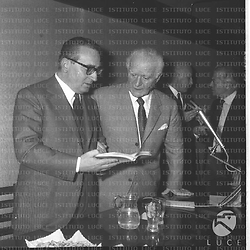 Gianni Granzotto e Leonida Repaci consultano un libro alla libreria Einaudi in occasione di una conferenza stampa per il  premio Viareggio - piano americano
