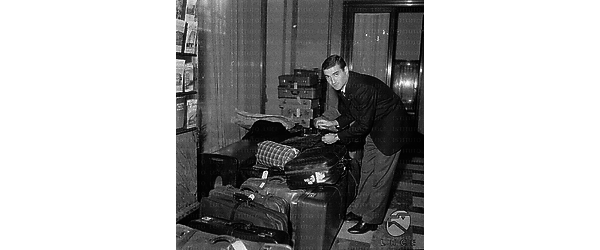 Guarnacci  stringe le cinghie della sua valigia accatastata insieme agli altri bagagli degli uomini della nazionale italiana di calcio.
