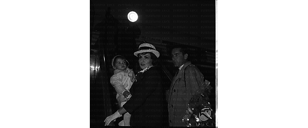 Gina Lollobrigida con in braccio il figlio Milko jr e accanto il marito Milko Skofic, sulla scaletta di un aereo in partenza per l'America - piano americano