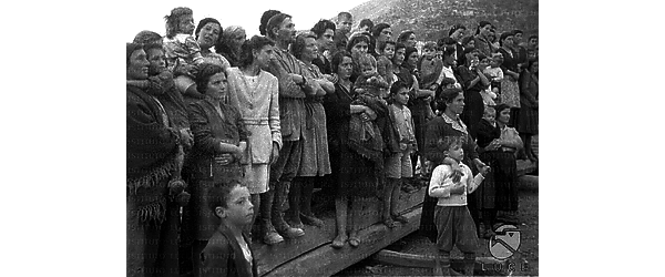 Cassino Un gruppo di persone poveramente vestite, vittime dei bombardamenti di Cassino, assiste alla visita di De Nicola