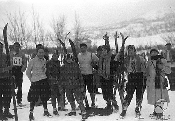 Un gruppo di partecipanti alla gara si appoggia su sci e racchette