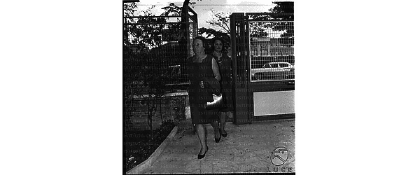 Rosa Fanfani seguita dalla figlia (Anna Maria o Maria Grazia) varca il cancello d'ingresso nella clinica - totale