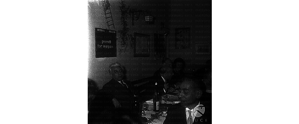 Giuseppe Longo e Scelba seduti ad una tavola con altre persone. Piano medio