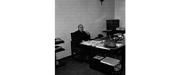 Roma Ezio Vigorelli seduto a una scrivania in un ufficio di dirigente dell'Istituto Nazionale Luce