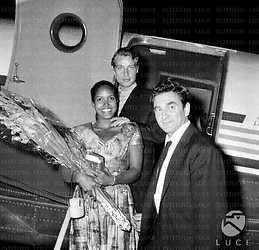 Marpessa Dawn e Marcel Camus sulla scaletta dell'aereo, l'attrice tiene in mano un mazzo di fiori; un uomo accanto a loro