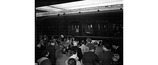 Roma Dunn, affacciato al finestrino di un treno che lo porterà nella sua nuova sede di Parigi, saluta la folla venuta ad accompagnarlo