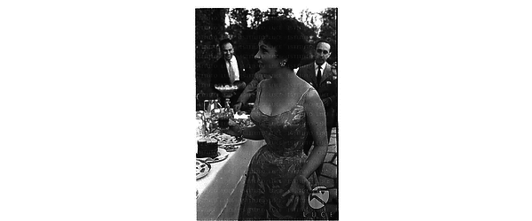 Gina Lollobrigida al tavolo del buffet durante un ricevimento nella sua villa per la ripresa della sua attività cinematografica - piano americano