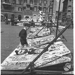 Un bambino a piazza Navona gioca accanto a strutture per cartelloni pubblicitari - totale