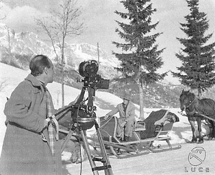 Cortina d'Ampezzo Un operatore alla macchina da presa sul set del film; sullo sfondo si vede una slitta trainata da un cavallo