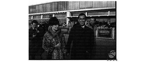 Petit Pascal e il regista Molinaro sulla pista dell'aeroporto di Ciampino ripresi dai fotografi - piano americano