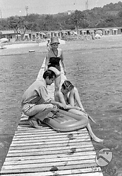 Serge Reggiani su un molo a passerella, con la moglie Annie Noel e il figlio Stephan, che sta indossando le pinne