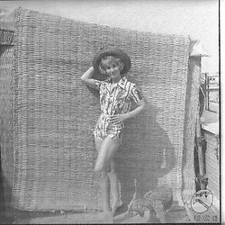 Luisa Rivelli  con  un cappello di paglia e  completino estivo posa vicino ad una stuoia - totale