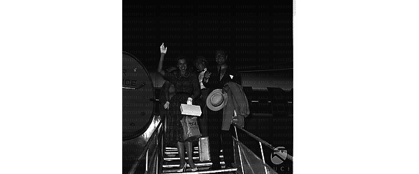 Cyd Charisse e Tony Martin ripresi mentre scendono dalla scaletta dell'aereo - totale