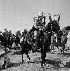 Mario Petri in abiti di scena e a cavallo sul set del film 'La regina dei Tartari' - campo medio