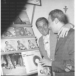 Perry Como con  un signore guradano le copertine dei suoi dischi - piano americano