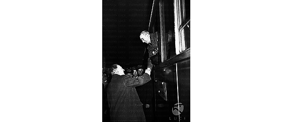 Roma Dunn, sporgendosi dal finestrino del treno diretto a Parigi, stringe la mano ad un uomo giunto a salutarlo