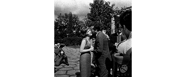 Gina Lollobrigida, circondata da giornalisti e fotografi nella sua villa sull'Appia Antica, viene baciata dal marito e dal figlioletto - piano americano