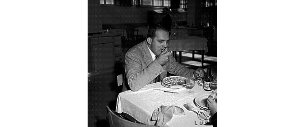 Il regista Damiani a tavola, mentre mangia un piatto di minestra; interno di un ristorante