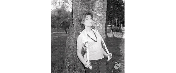 Pina Bottin in posa appoggiata ad un albero; esterno; piano americano