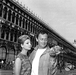 Michel Roney con una donna a piazza San Marco e sulla mano una colomba. Piano medio