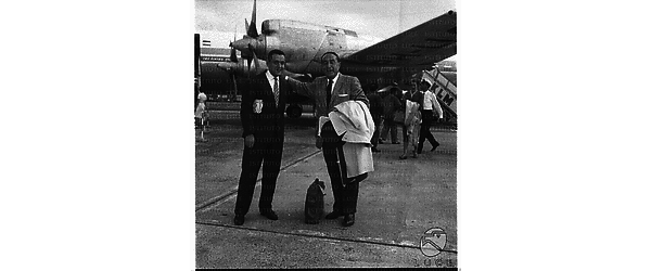 Il regista americano Irving Rapper, sulla destra, discorre con una persona sulla pista dell'aeroporto di Ciampino - totale