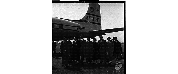 Momenti di arrivi e partenze con linee aeree Pan American: gruppo di orientali ripresi sotto la coda dell'aereo - campo medio