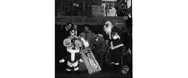 Il Quartetto Cetra sotto il palco, dove vengono raccolti i doni per i bambini, con la 'Befana' e 'Babbo Natale' - totale
