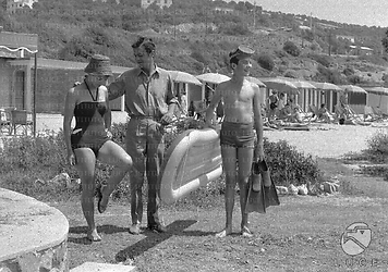 Serge Reggiani sulla spiaggia con la moglie Annie Noel e il figlio Stephan, entrambi in costume da bagno