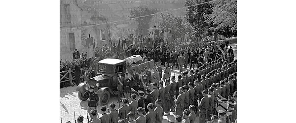 Predappio L'autoveicolo con il feretro di Bruno Mussolini percorre la strada verso il cimitero; il Duce e gli altri familiari seguono il camioncino; due ali di folla, militari e organizzazioni fasciste omaggiano il figlio del Duce