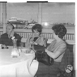 Pascale Petit e Marcel Carné seduti ad un tavolino nell'aeroporto di Ciampino. Piano medio