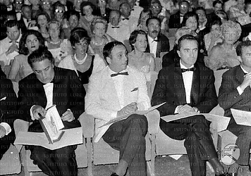 Cannes Fellini in platea con il premio in mano, ad un posto di distanza è seduto Antonioni