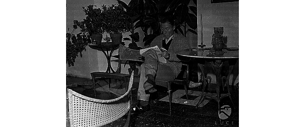 Paul Steffen seduto su una sedia in terrazza sfoglia una rivista. Campo medio