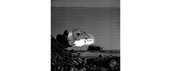 Corsica Un soldato con il lanciafiamme manda un getto di fuoco verso un cespuglio sulla spiaggia
