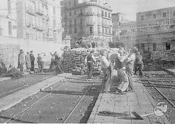 Napoli Gruppo di civili impegnati a costruire barricate di sacchi di sabbia, paglia e rami per permettere ai militari di far brillare ordigni inesplosi nella stazione tramviaria