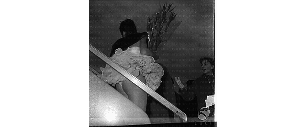 Vera Tschechowa ripresa sulla scaletta dell'aereo di spalle con dei fiori in mano - piano americano