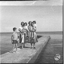 Ingrid Bergman e Friedel Pia Lindstrom, con in braccio le piccole Isotta e Isabella Rossellini, sono colte su un piccolo molo di S. Marinella. Il piccolo Robertino le precede. Campo medio