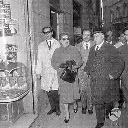 Edda Ciano Mussolini cammina in strada, accompagnata da un gruppo di uomini
