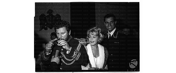 Sandra Dee ripresa sorridente tra John Gavin e Peter Ustinov in abiti di scena durante il rinfresco occasionato dalle riprese del film 'Giulietta e Romanoff' - piano medio