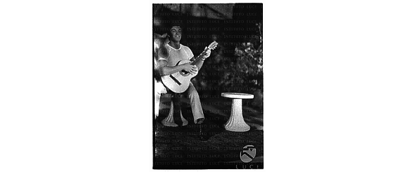 Giovane uomo suona la chitarra durante il ricevimento in casa Roloff - totale