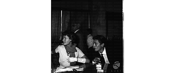 Romy Schneider e Alain Delon seduti a un tavolino, piano medio