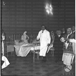 Il papa Giovanni XXIII accompagnato da Fanfani e da un medico (il professore Piero Alonzo ?) in una corsia dell'ospedale. Campo medio