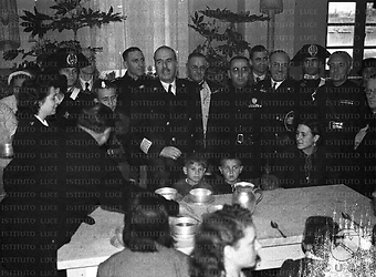 Roma Autorità posano nella sala mensa, intorno a un tavolo dove siedono bambini e lavoratori