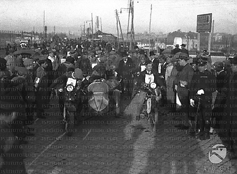Gruppo di motociclisti alla partenza in una strada di periferia. Campo lungo