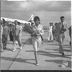 L'attrice Pascale Petit con un fascio di fiori sulla pista dell'aeroporto di Ciampino. Totale