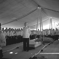 Messa a bordo di una nave da guerra: il comandante della nave, gli ufficiali e i marinai schierati sul ponte della nave