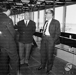 L'avvocato Martucci e Romolo Marcellini conversano con un uomo di spalle all'interno dell'aeroporto di Fiumicino; totale