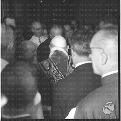 Ripreso di spalle il papa Giovanni XXIII circondato da tante persone all'ingresso dell'ospedale di Santo Spirito in Sassia a Roma. Sulla sinistra si distingue Fanfani. Piano medio