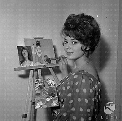 L'attrice Stefania Sabatini in casa mentre dipinge, sul cavalletto una fotografia di Sophia Loren - medio primo piano